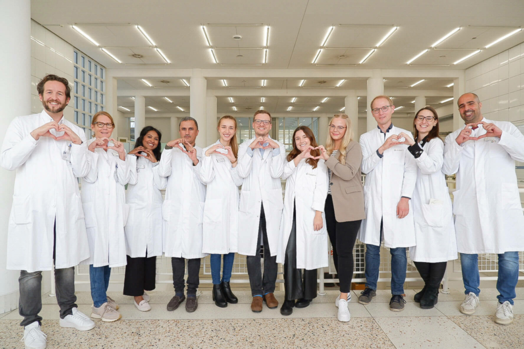 Ärzteteam der Kinderchirurgie mit Herzgeste im Klinikflur