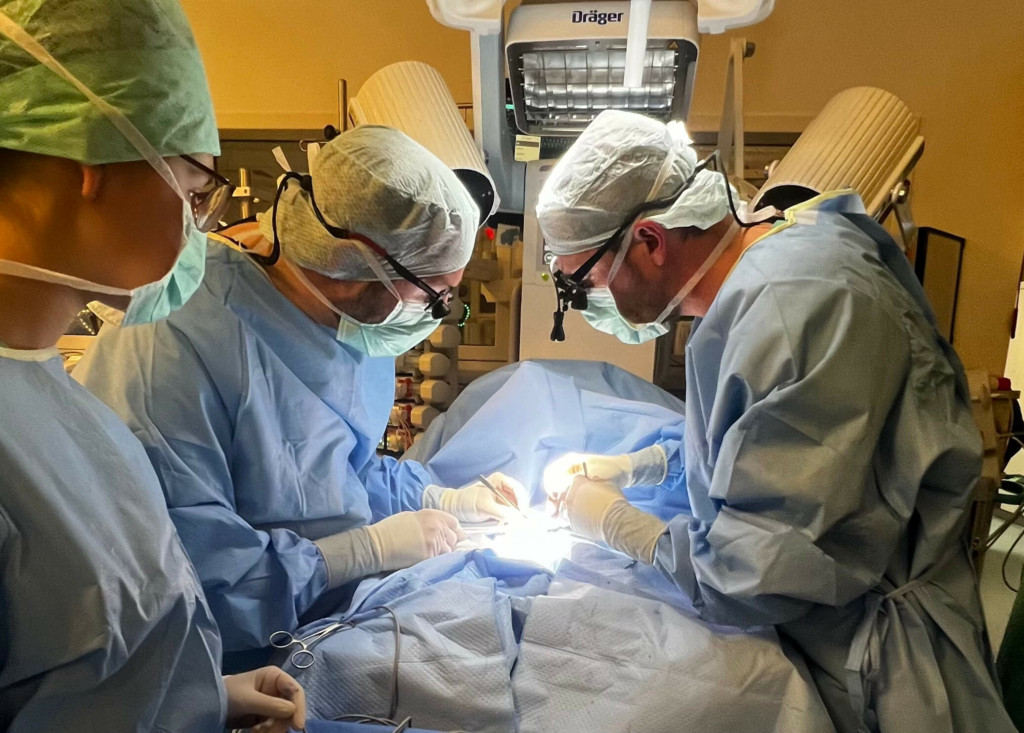 Chirurgenteam in OP-Kleidung führt eine Operation im Operationssaal durch.